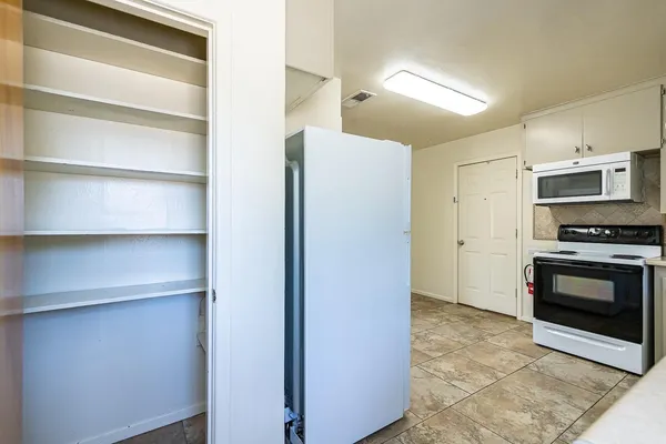 a view of washer and dryer with white cabinets