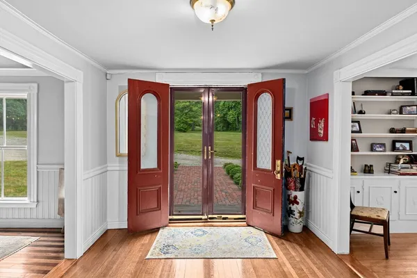 a view of entryway with a front door and wooden floor