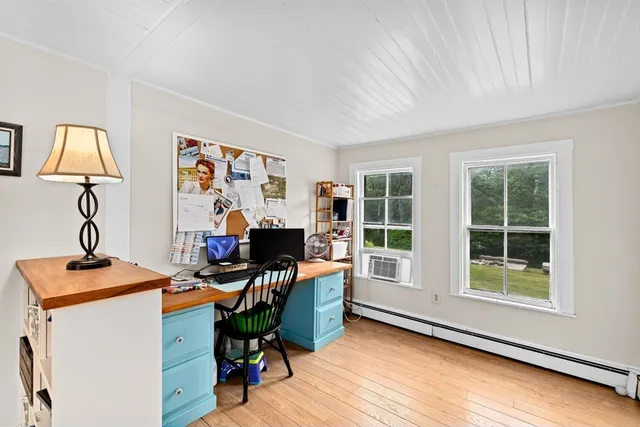 a view of a workspace with furniture and a window