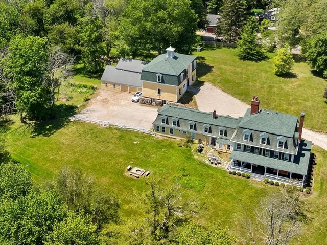 an aerial view of residential houses with outdoor space and trees