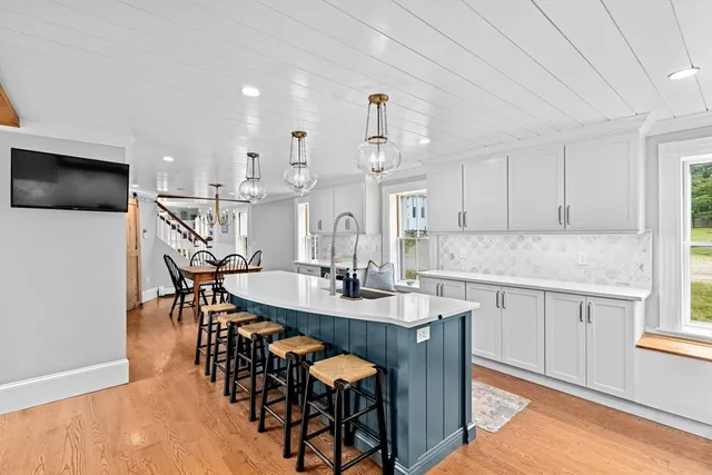 a kitchen with stainless steel appliances kitchen island granite countertop a dining table chairs and granite counter tops