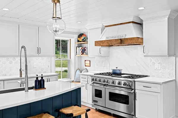 a kitchen with stainless steel appliances a sink a stove and a window