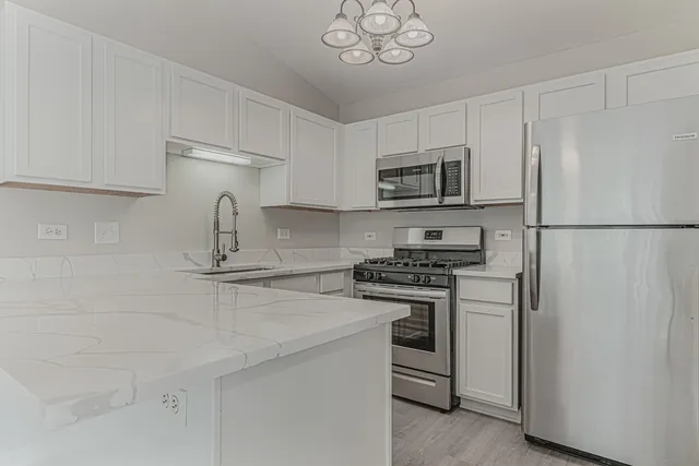 a kitchen with stainless steel appliances a refrigerator stove and microwave