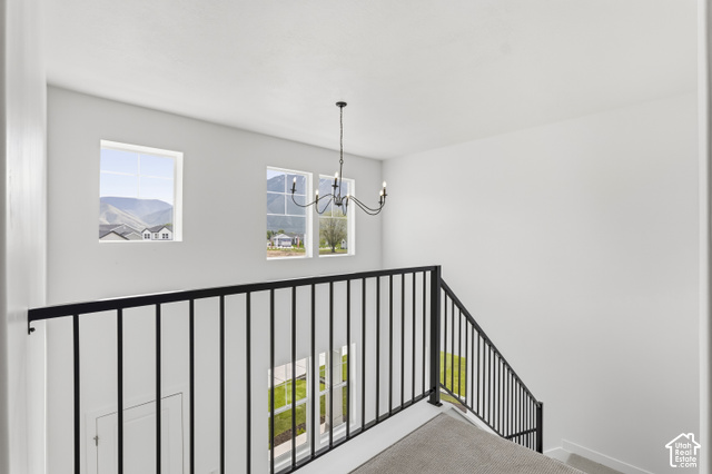 79 South Crimson Way West, Unit 307 Mapleton, UT 84664 - Photo 22 of 42 Black iron railing, white walls, black chandelier, and carpeted stairs
