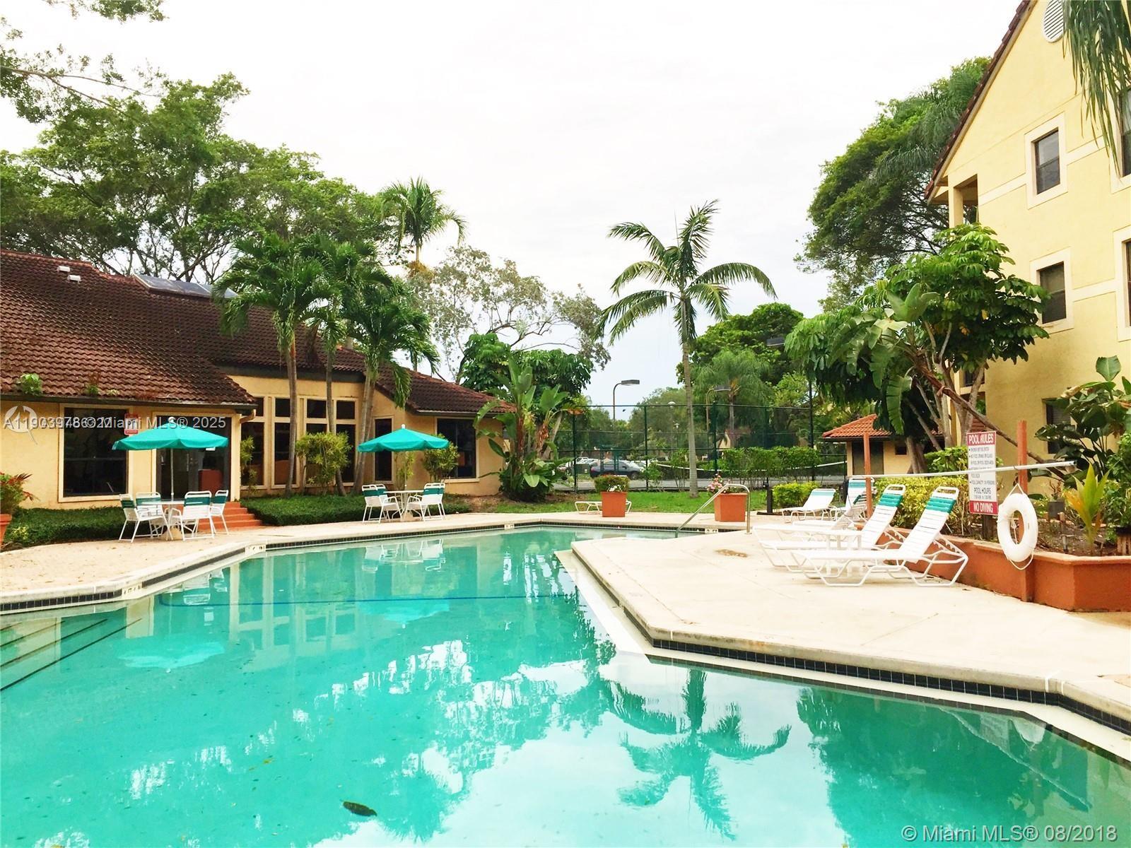 4541 West McNab Road, Unit 16 Pompano Beach, FL 33069 - Photo 19 of 23 a swimming pool with outdoor seating and yard