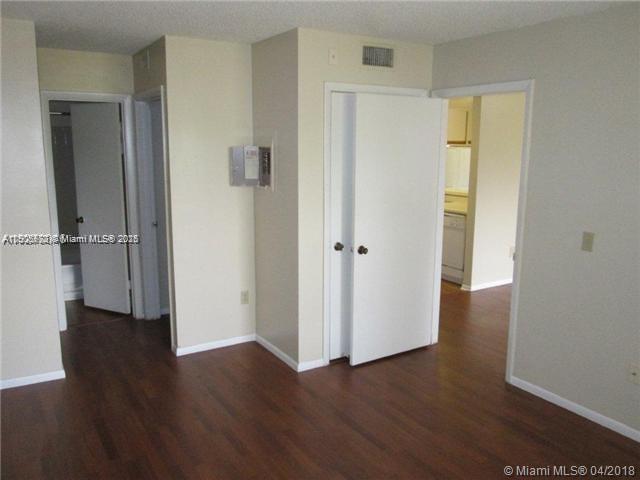 4541 West McNab Road, Unit 16 Pompano Beach, FL 33069 - Photo 4 of 23 an empty room with wooden floor and closet