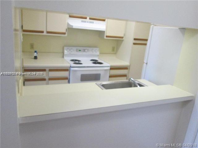 4541 West McNab Road, Unit 16 Pompano Beach, FL 33069 - Photo 6 of 23 a kitchen with a stove and a refrigerator
