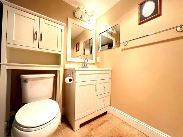 a bathroom with a toilet a sink and mirror