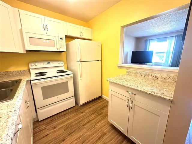 a kitchen with white cabinets and white appliances