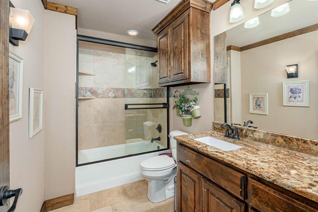 3028 Harrell Road Howe, TX 75459 - Photo 19 of 39 a bathroom with a granite countertop sink toilet a mirror and shower