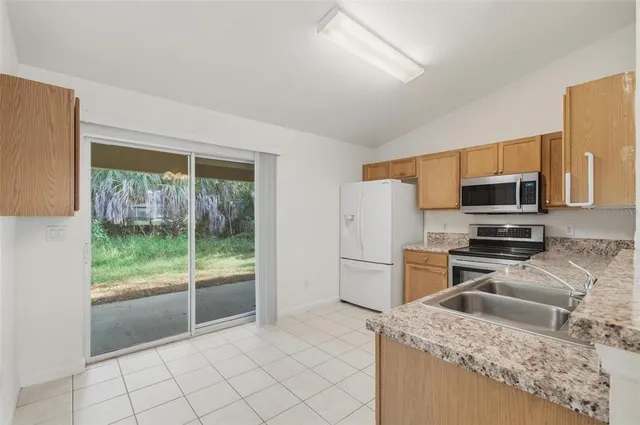 a kitchen with granite countertop cabinets stainless steel appliances and a counter space