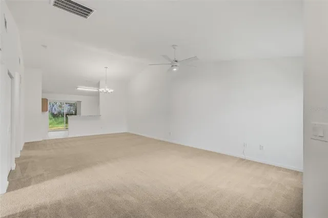 an empty room with a white walls and ceiling fan