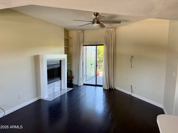 a view of a hallway with wooden floor and a living room