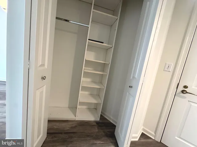 a view of a room with wooden floor and chandelier