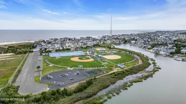 an aerial view of a residential houses with outdoor space and ocean view