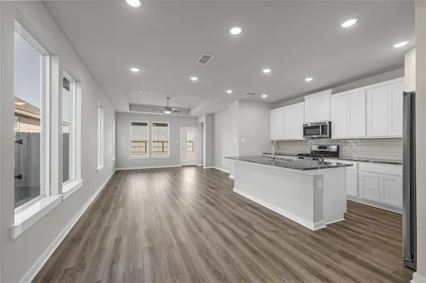 a kitchen with stainless steel appliances granite countertop a stove a sink and a refrigerator