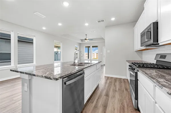 a kitchen with stainless steel appliances granite countertop a stove a sink and a refrigerator