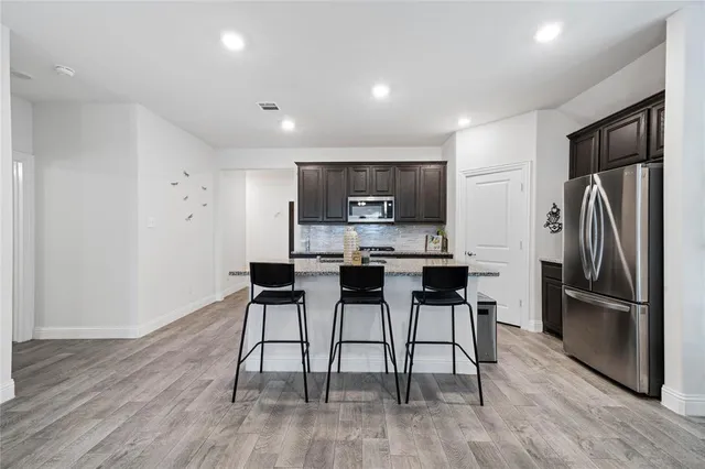 a kitchen with stainless steel appliances a refrigerator stove microwave and cabinets