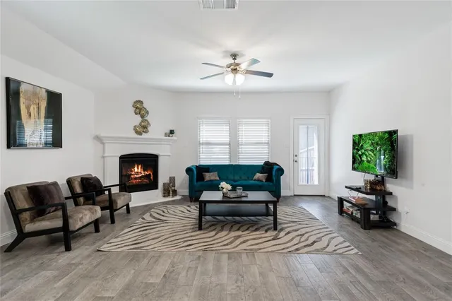 a living room with furniture a fireplace and a flat screen tv
