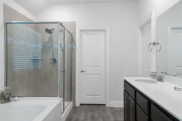 a bathroom with a granite countertop sink shower and a bathtub