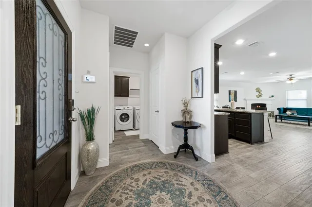 a living room with stainless steel appliances kitchen island granite countertop a refrigerator and a sink
