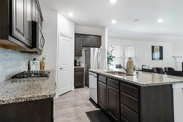 a kitchen with stainless steel appliances granite countertop a sink stove and refrigerator