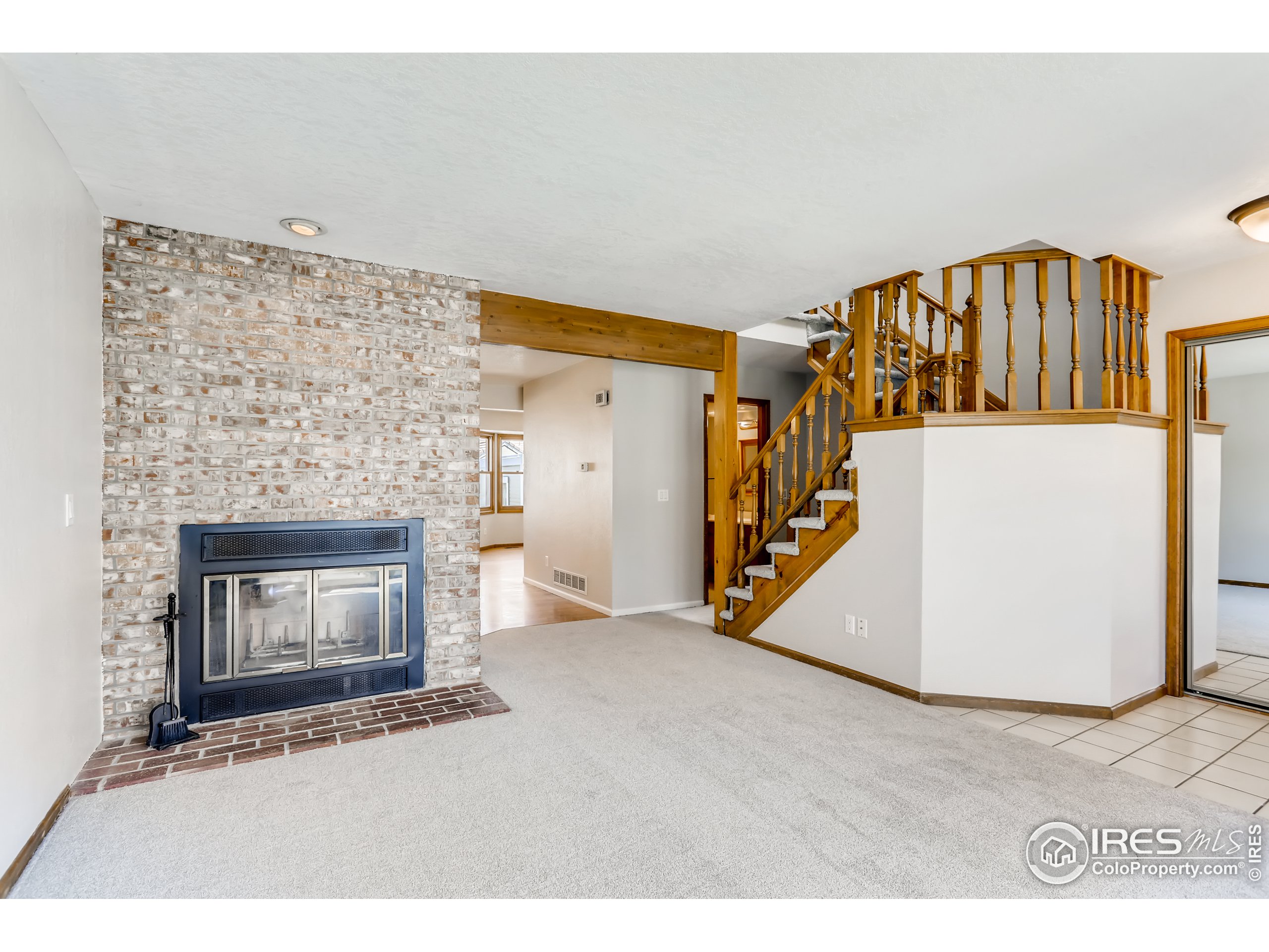 2315 Ranch Drive Westminster, CO 80234 - Photo 3 of 28 a view of an empty room with wooden floor and a fireplace