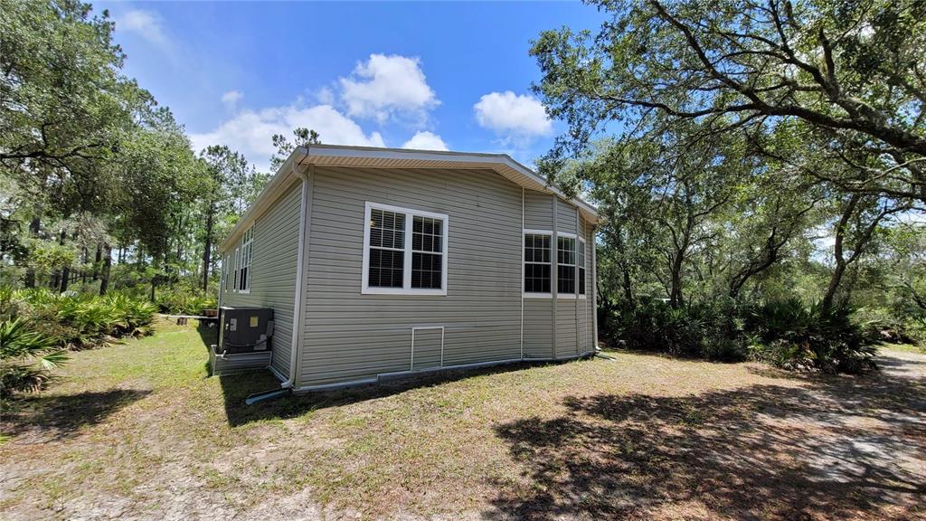 3690 Southeast 54th Avenue Morriston, FL 32668 - Photo 18 of 43 a front view of a house with a yard