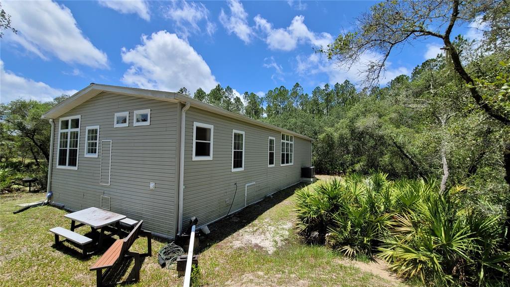 3690 Southeast 54th Avenue Morriston, FL 32668 - Photo 21 of 43 a view of backyard of house with outdoor seating