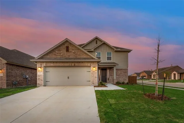 a front view of a house with a garden and yard