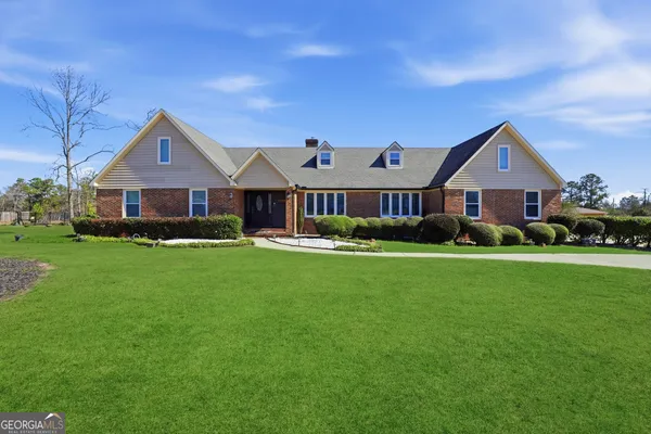 a front view of a house with a yard and green space