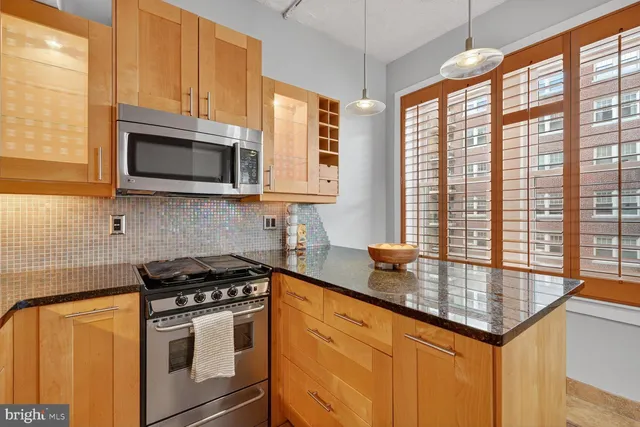 a kitchen with stainless steel appliances granite countertop a stove sink and microwave
