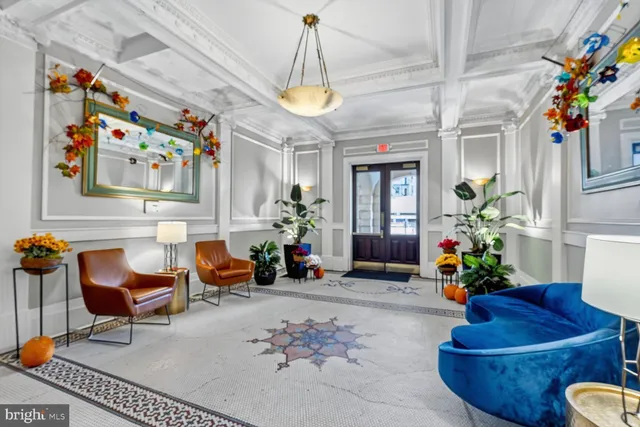 a living room with furniture flowers and a chandelier