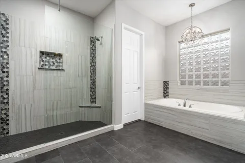 a bathroom with a tub sink double vanity granite and shower