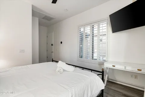 a bedroom with a bed and a flat tv screen on the dresser