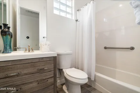 a bedroom with a bed and a flat tv screen on the dresser