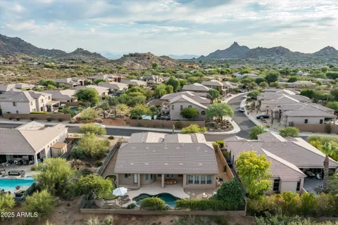 an aerial view of a house with a mountain in the background