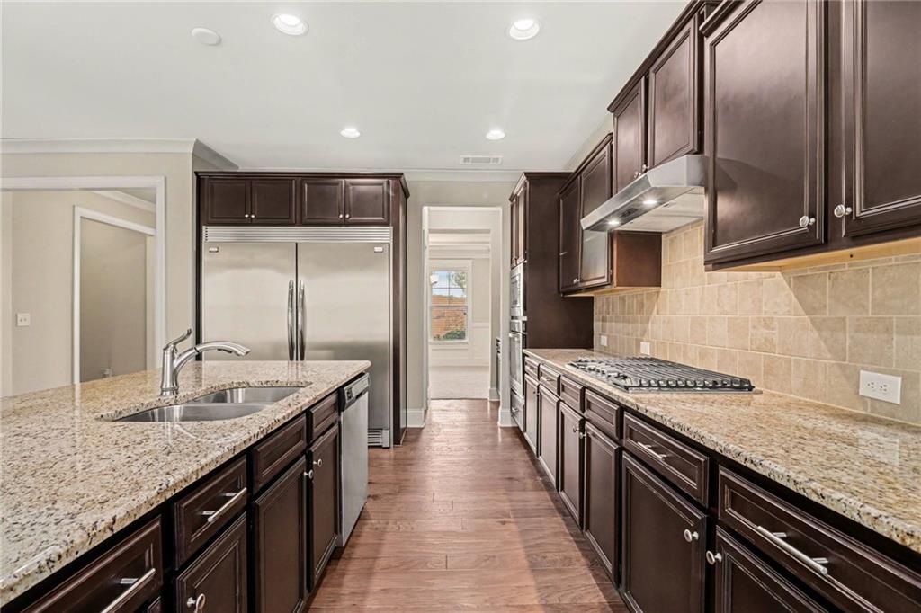 2960 Hampton Grv Trace Dacula, GA 30019 - Photo 12 of 33 a kitchen with stainless steel appliances granite countertop a sink stove and refrigerator