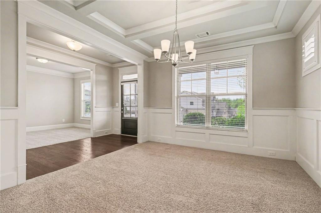 2960 Hampton Grv Trace Dacula, GA 30019 - Photo 8 of 33 an empty room with wooden floor chandelier and glass door