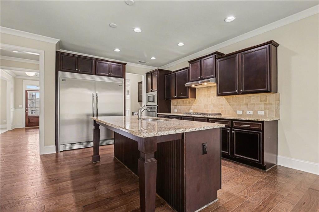 2960 Hampton Grv Trace Dacula, GA 30019 - Photo 10 of 33 a kitchen with kitchen island granite countertop wooden cabinets a refrigerator and a stove