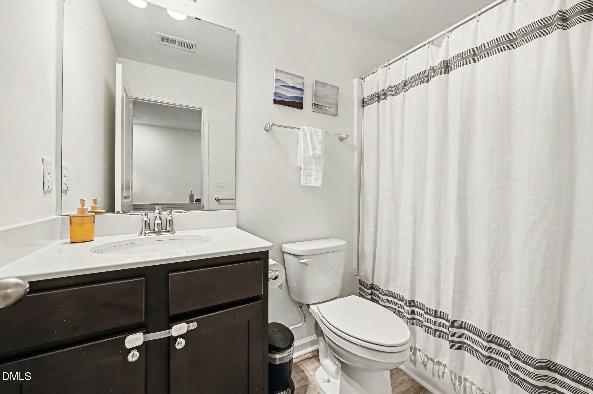 574 Hacksaw Trail Raleigh, NC 27610 - Photo 19 of 28 a bathroom with a granite countertop sink toilet and a mirror