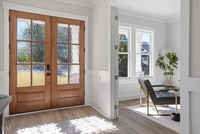 a living room with couches and a dining table with wooden floor