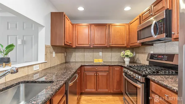 a kitchen with stainless steel appliances granite countertop a sink stove and cabinets