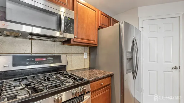 a kitchen with stainless steel appliances granite countertop a stove and a refrigerator