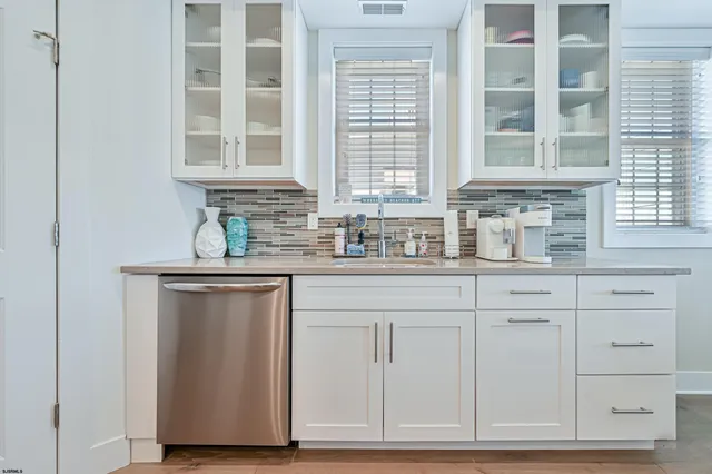 a kitchen with white cabinets and sink
