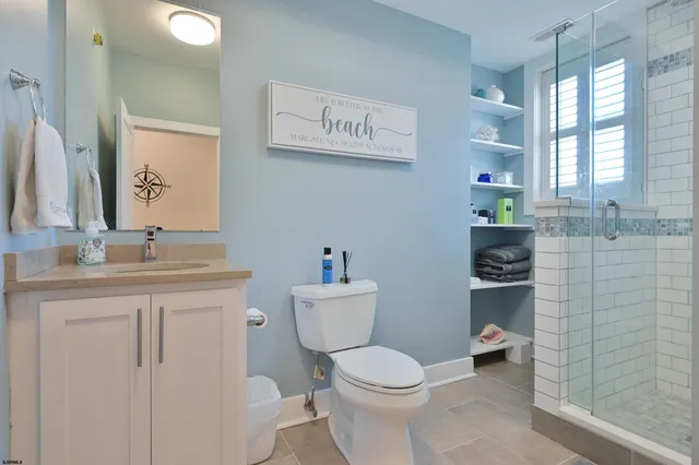 a bathroom with a granite countertop toilet sink and mirror