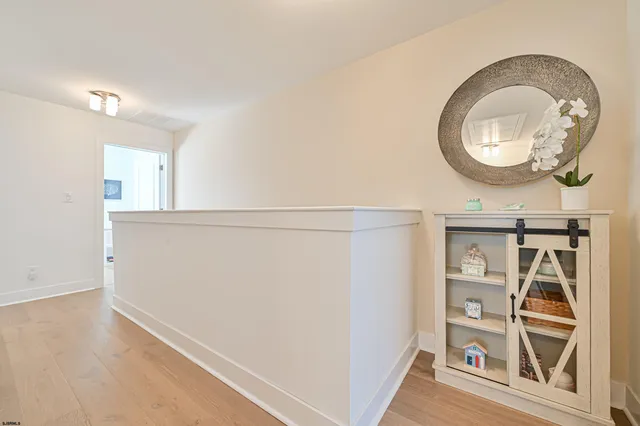 an entryway with wooden floor and a mirror