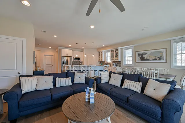 a living room with furniture and a view of kitchen