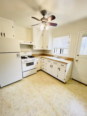 a kitchen with granite countertop a stove a sink dishwasher and a refrigerator