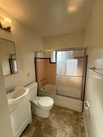 a white toilet sitting next to a bathroom sink and a shower